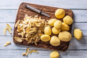 Peeled potatoes on a cutting board - top of view.