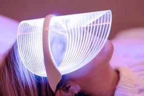 A woman wearing an LED face mask