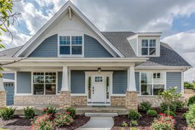 Blue house with stonework and landscaped front yard