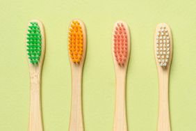 Bamboo toothbrushes on a green background. Top view.