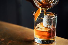 Coffee old fashioned being poured into a glass.