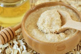 Homemade honey and oatmeal face mask in wooden bowl with spoon