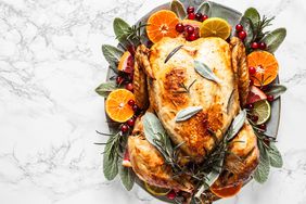 Cooked Thanksgiving Turkey on a Serving Platter With Orange, Cranberry, and Sage Garnish