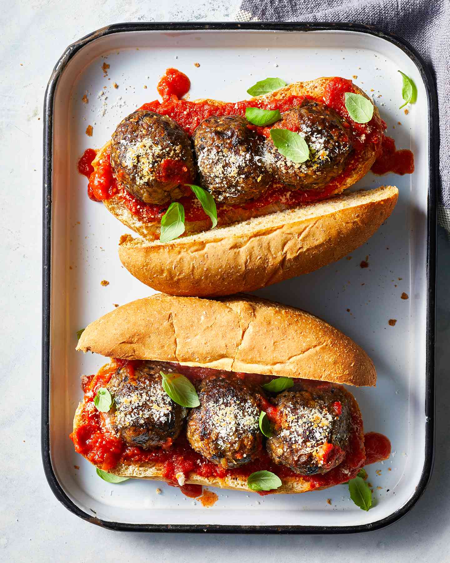 Two Meatless Eggplant-Mushroom Meatball Subs on a Baking Sheet