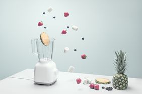 blender with a variety of fruits, vegetables, and coffee beans