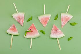 Frozen watermelon popsicles on trendy Savannah green background. Refreshing summer dessert, flat lay, top view