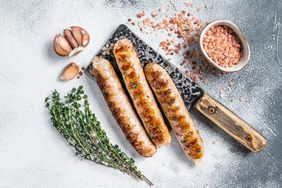 Grilled Bockwurst and Bratwurst meat sausages on a cleaver.