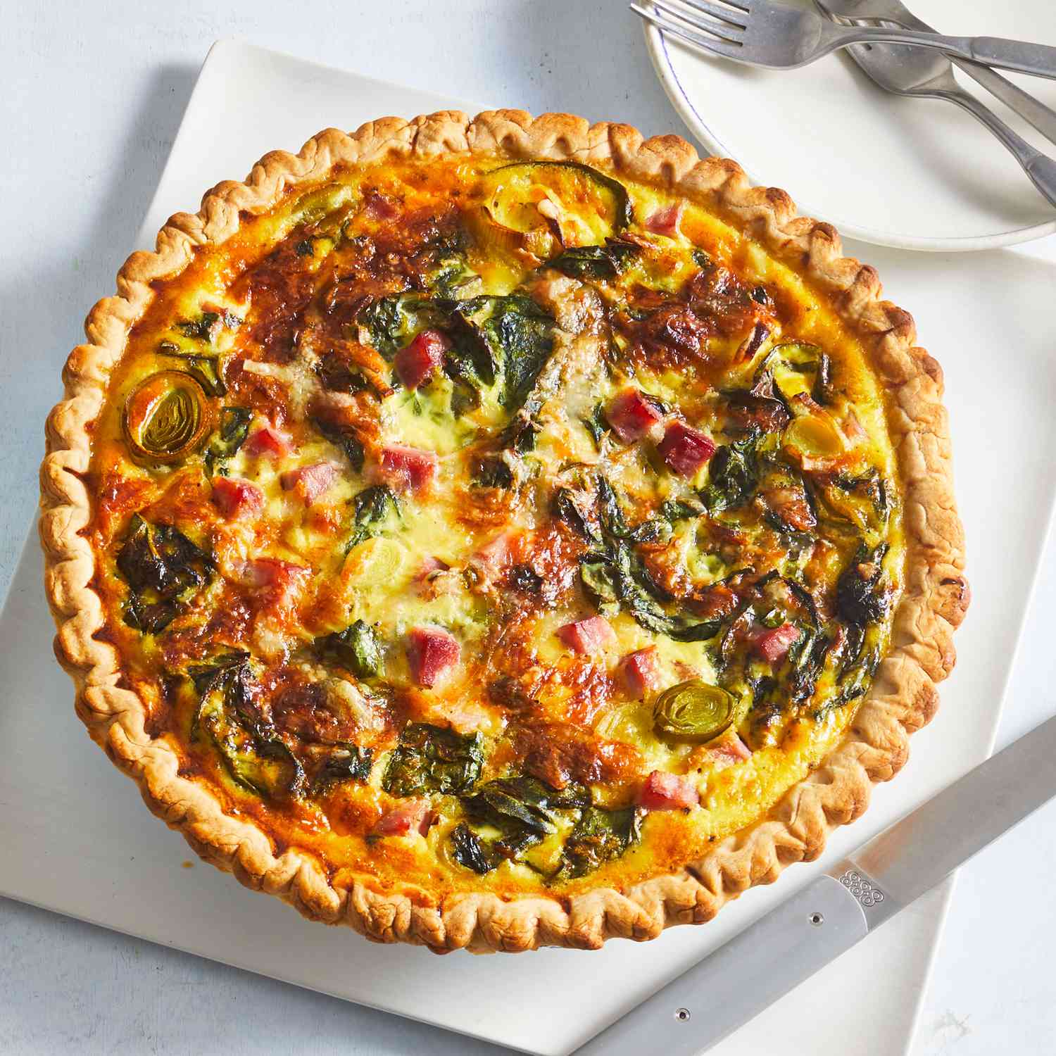 Ham and leek quiche displayed on a white background.