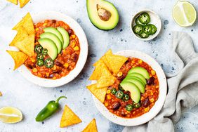 Vegetarian chili con carne with lentils, beans, nachos, lime, jalapeno. Mexican traditional dish