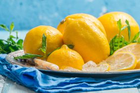 Fresh slice lemon with ice on metal tray over the blue wooden table