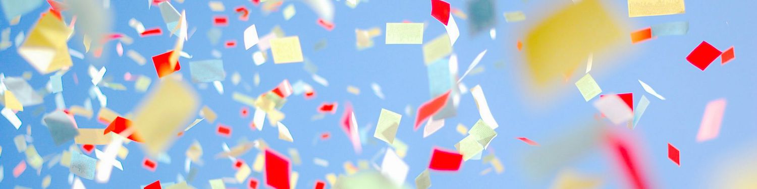 Colorful confetti thrown in the air against a blue background for celebrating holidays and special occasions