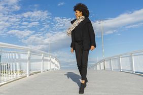 This Is How Much Exercise Is Needed to Offset a Day of Sitting: woman walking outside across a bridge