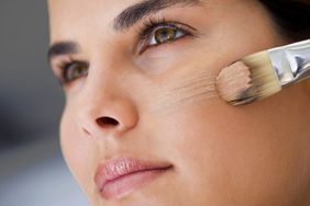 Woman applying foundation with a brush