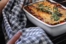 how to broil: person taking broiled food out of the oven