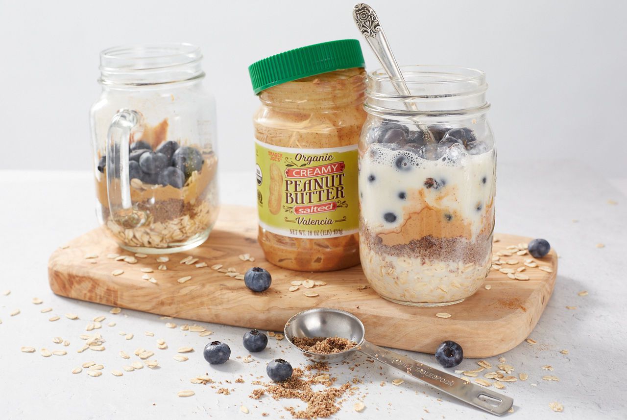 Trader Joe's Organic Creamy Peanut Butter Salted Valencia, used in recipe for overnight oats, prepared in two glass jars, with fresh blueberries, ground flaxseed and one with alt milk