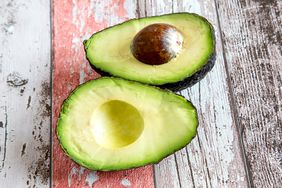 A slices avocado on a textured wooden surface