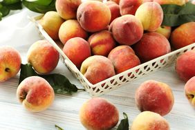 Sweet peach fruit in tray on white wooden table