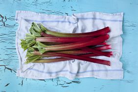 A stack of rhubarb stalks on a white cloth napkin