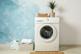 Laundry room with washing machine against light blue wall, space for text