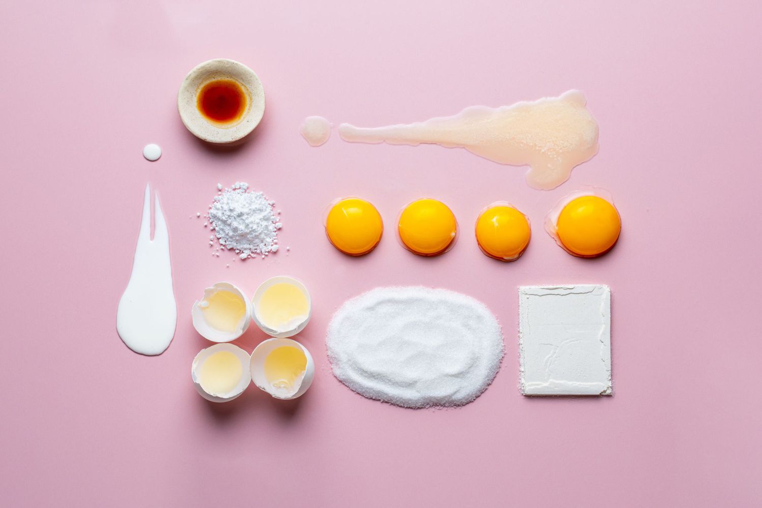 overhead view of cake ingredients on a pink surface