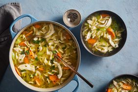 Chicken Noodle Soup, an easy make ahead meal, served in a Blue Cooking Pot With a Metal Ladle and Two Bowls of Soup on the Side