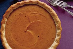 Top View of Maple Pumpkin Pie on Top of Purple Fabric with Two Metal Forks Next to It