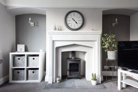 A general interior view of a white and grey painted lounge with wood burner fireplace