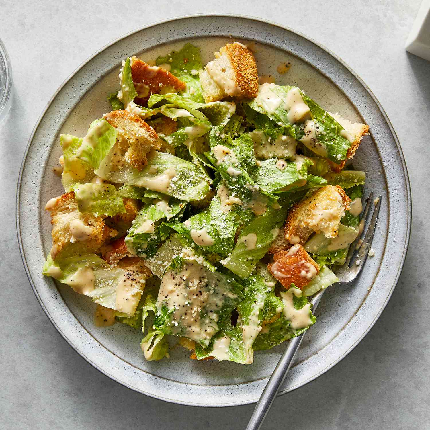 Top View of Miso Caesar Salad in a Bowl with Metal Fork in Food