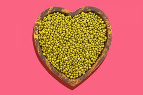 Directly Above Shot Of Mung Beans In Heart Shape Bowl Over White Background