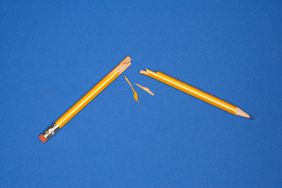 pencil broken in half on a blue background