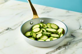 Courgette cut into slices in an iron pan - stock photo