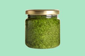 Jar of pesto on green background