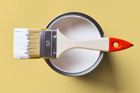 Brush On A Jar Of White Paint, On A Bright Yellow Background. Painting And Repair Work