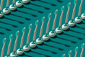 Green Colored Biodegradable Bamboo Wood Toothbrushes Arranged in Rows on Green Background.