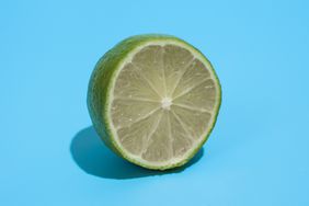 Ripe juicy delicious lime on blue background