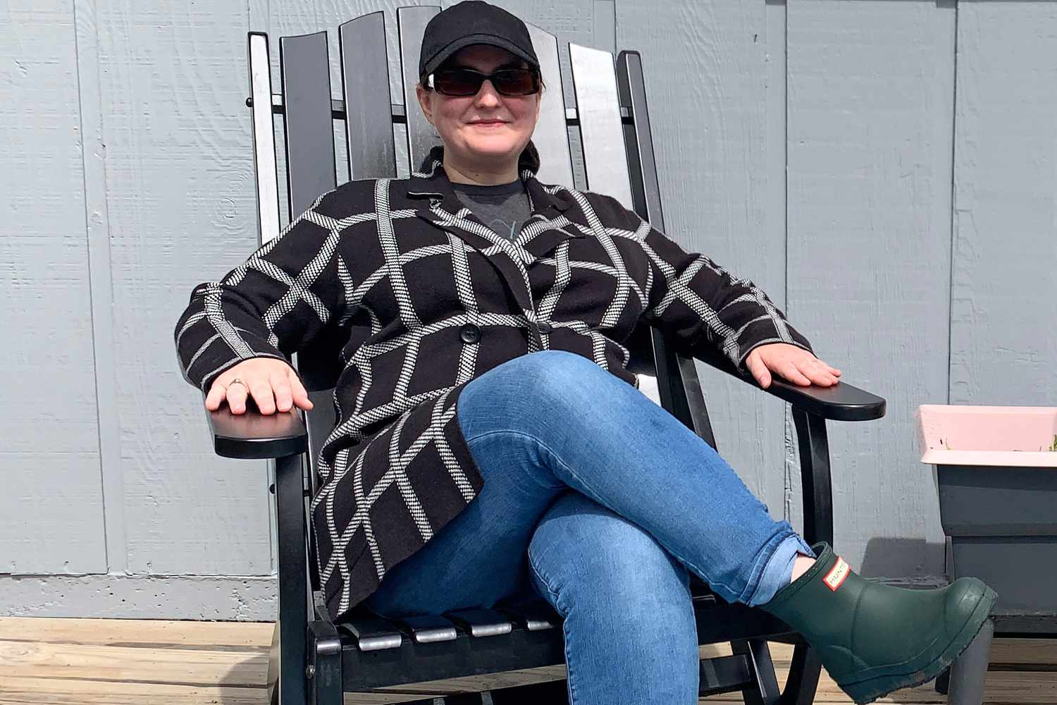 A person relaxing on the Grandin Road Newcomb Adirondack Chair