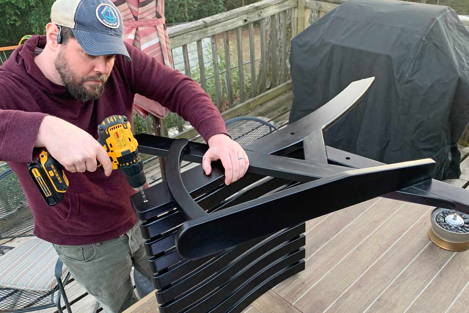 A person using a power tool on the Grandin Road Newcomb Adirondack Chair