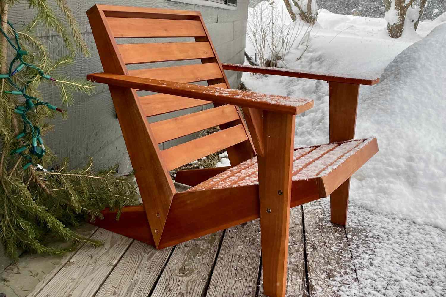 The Joss & Main Ursa Acacia Outdoor Adirondack Chair dusted in snow