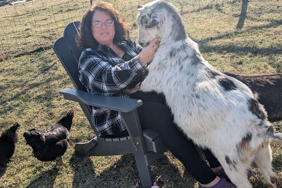 A person and goat on top of the KINGYES Folding Adirondack Chair