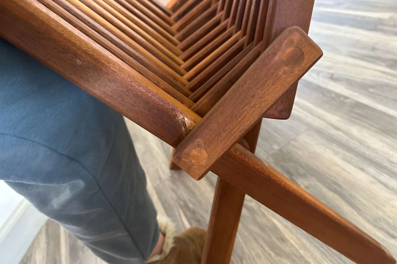 A person folding the Sand and Stable Abingdon Wood Folding Adirondack Chair