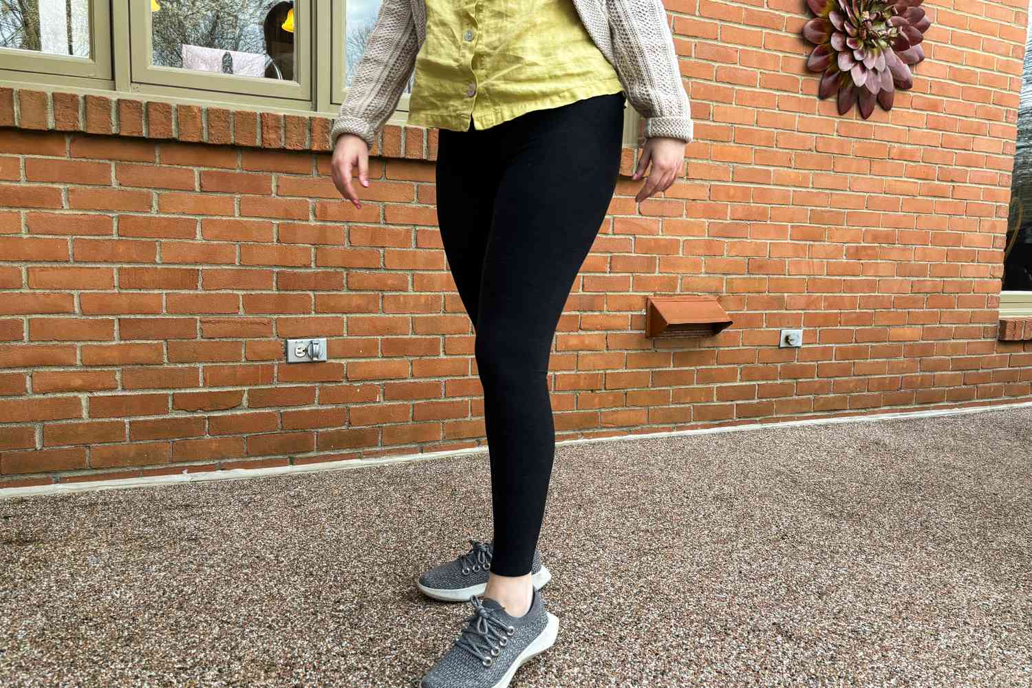 A person stands outside while wearing the Vuori Elevation Ruched Legging