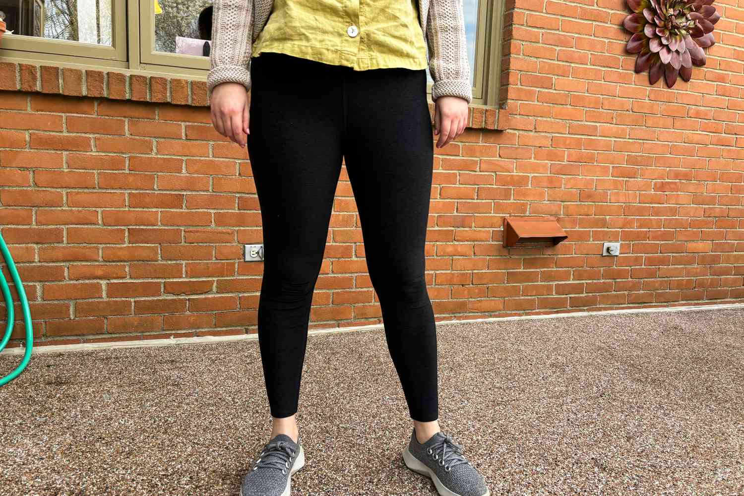 A person stands outside while wearing Vuori Elevation Ruched Leggings