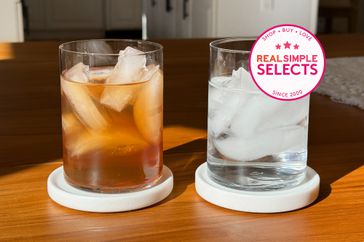 two glasses holding iced tea and water with ice on a table