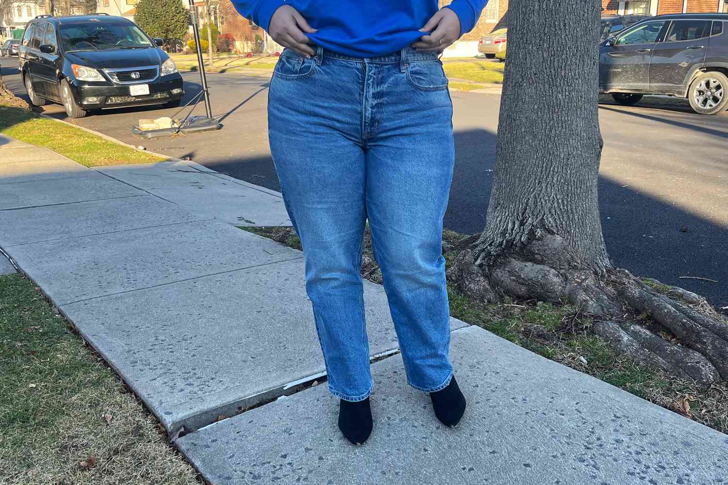 Showing the front of a person wearing American Eagle AE Stretch Super High-Waisted Ankle Straight Jeans outdoors