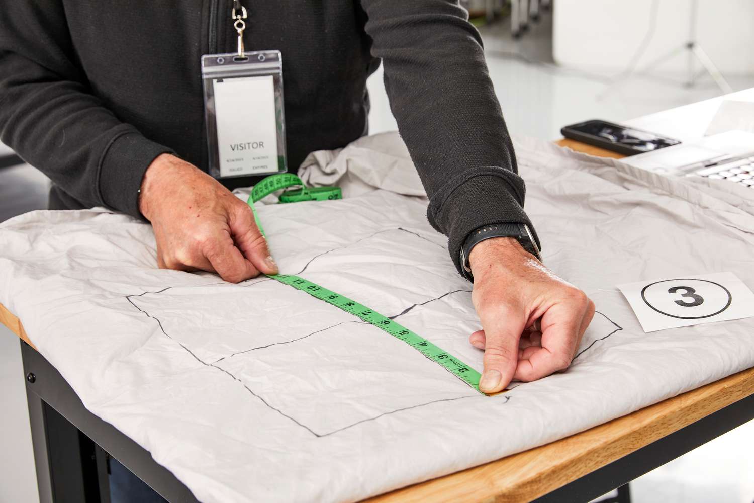 Person using measuring tape to measure a section of the Pact Cool-Air Percale Sheet Set