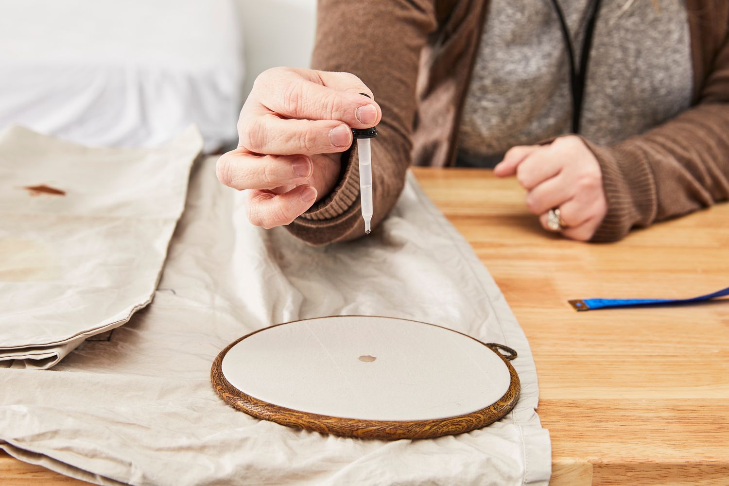 A person adding drops of water on the West Elm 400-Thread-Count Organic Percale Pleated Edge Sheet Set