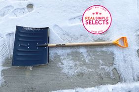 snow shovel lays on snowy ground