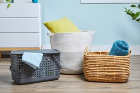 Three of the best storage baskets on a wood floor in a blue room with a dresser in the background. 