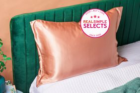 A silk pillow case we recommend on a pillow that is on a green velvet bed 