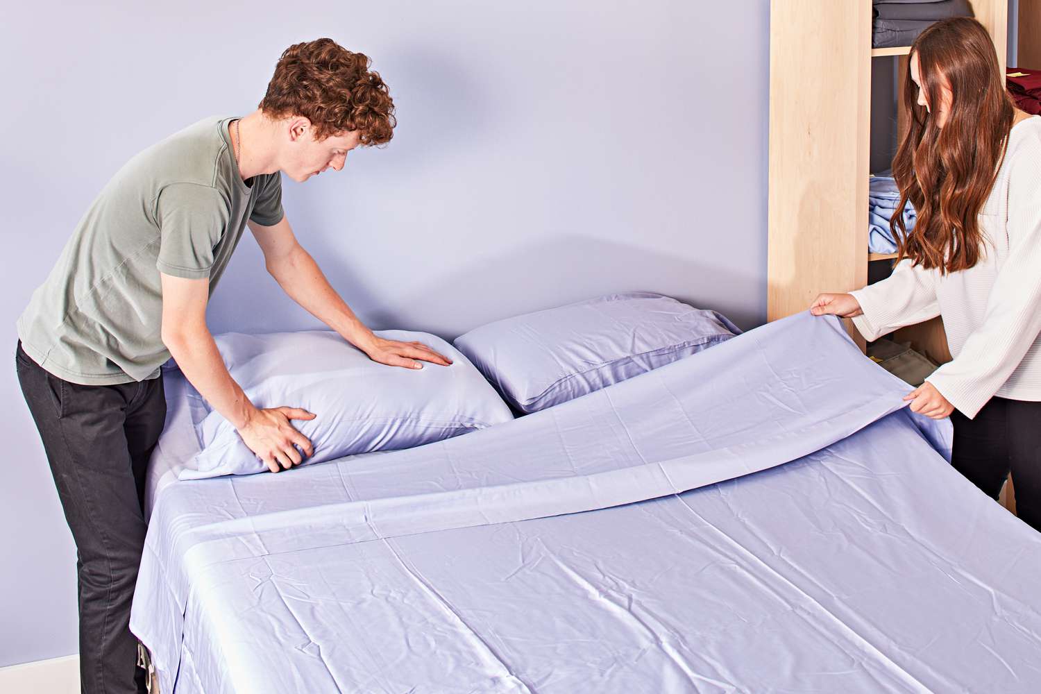 Two people making bed with Sijo AiryWeight Eucalyptus Sheet Set